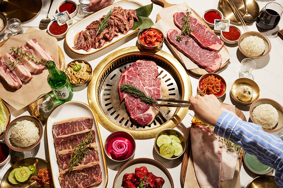 Table of various Korean Grill dishes, person grilling, Sumi Korean Grill.